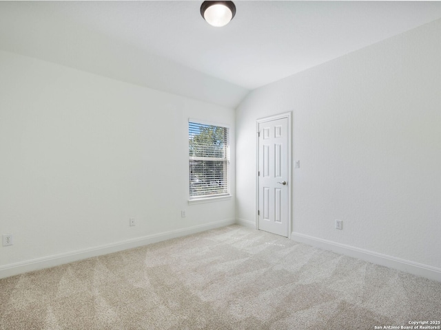 empty room featuring light carpet and lofted ceiling