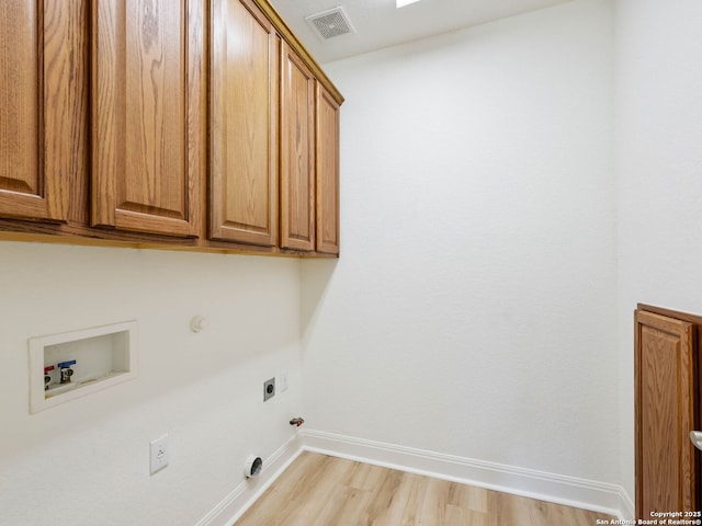 laundry room featuring washer hookup, gas dryer hookup, cabinets, light hardwood / wood-style floors, and electric dryer hookup