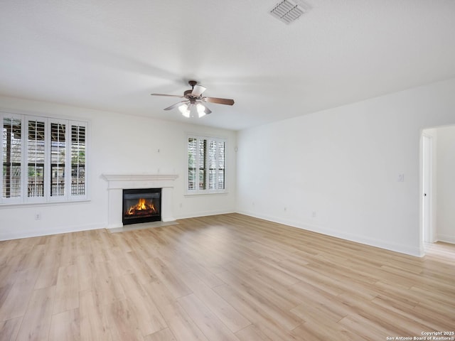 unfurnished living room featuring ceiling fan and light hardwood / wood-style floors