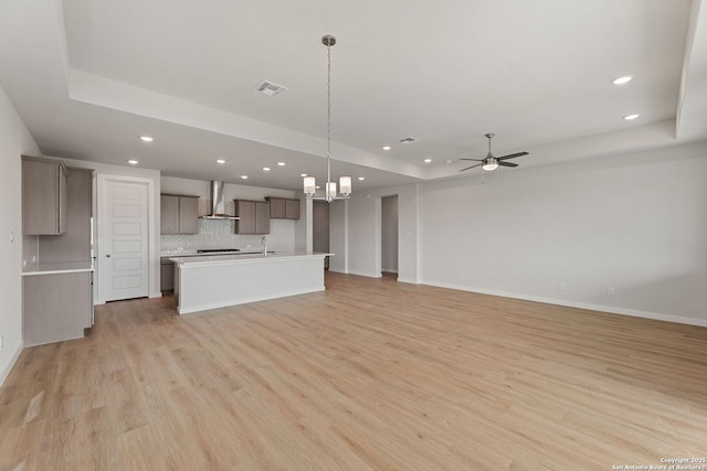 125 Connor Crk, San Antonio, TX 78253 - kitchen featuring a raised ceiling, wall chimney range hood, open floor plan, recessed lighting, and ceiling fan