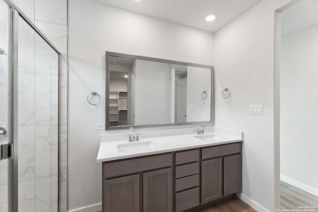 125 Connor Crk, San Antonio, TX 78253 - full bathroom featuring double vanity, wood finished floors, a stall shower, and baseboards