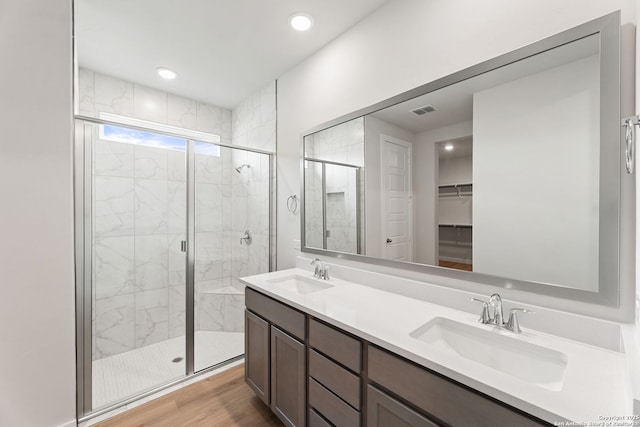 125 Connor Crk, San Antonio, TX 78253 - bathroom with a shower stall, double vanity, a walk in closet, wood finished floors, and recessed lighting