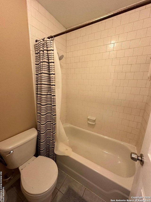 bathroom with tile patterned flooring, toilet, and shower / tub combo