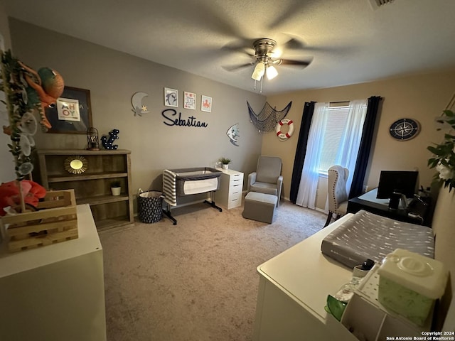 bedroom featuring a textured ceiling, ceiling fan, and light colored carpet