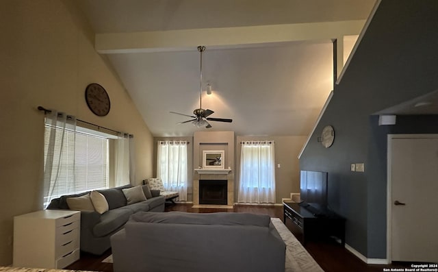 living room featuring a tile fireplace, ceiling fan, beamed ceiling, and dark wood-type flooring