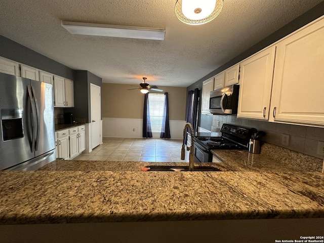 kitchen featuring appliances with stainless steel finishes, ceiling fan, sink, and white cabinets