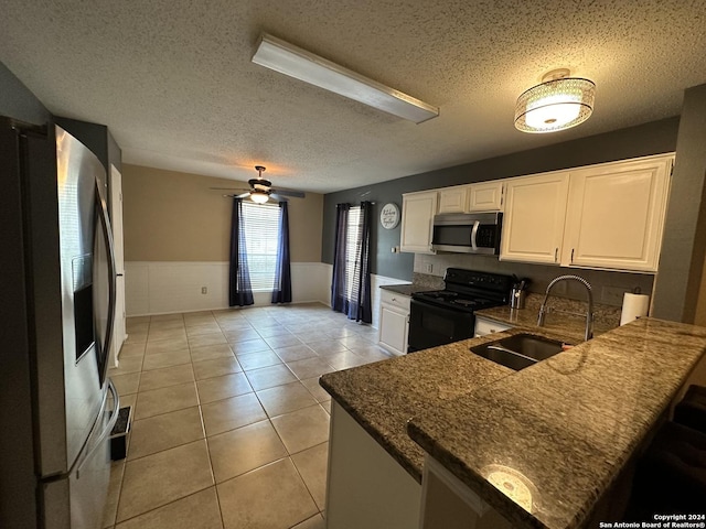 kitchen with white cabinetry, kitchen peninsula, stainless steel appliances, sink, and light tile patterned floors