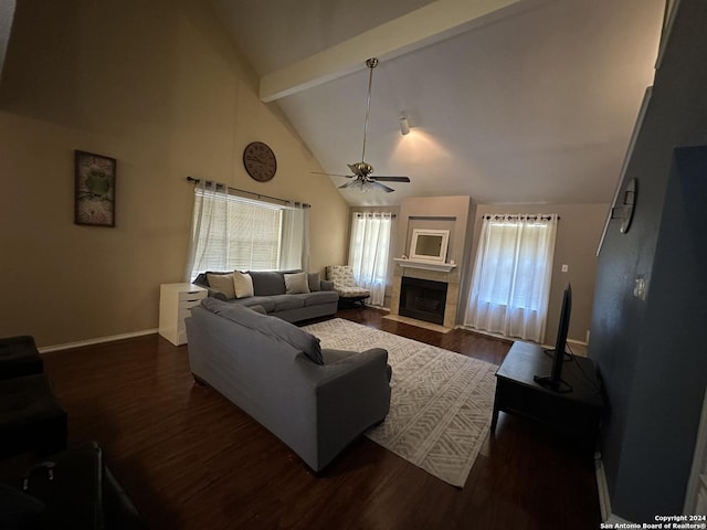 living room with ceiling fan, a tiled fireplace, dark hardwood / wood-style flooring, and beam ceiling