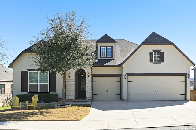 view of front of home featuring driveway, a shingled roof, and stucco siding