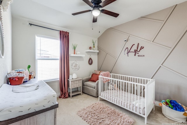 bedroom featuring carpet, a nursery area, and ceiling fan