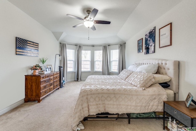 carpeted bedroom with a tray ceiling and ceiling fan