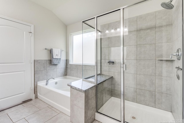 bathroom with plus walk in shower, vaulted ceiling, and tile patterned floors