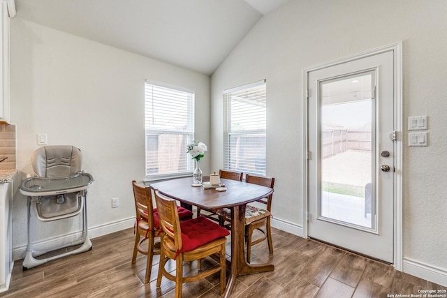 dining room with vaulted ceiling and hardwood / wood-style flooring