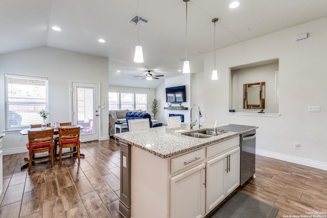 kitchen featuring a kitchen island with sink, hanging light fixtures, sink, light stone counters, and dishwasher