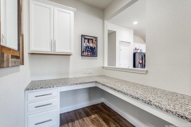 interior space featuring dark wood-type flooring and built in desk