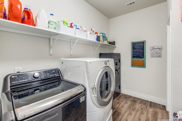 clothes washing area with hardwood / wood-style floors and separate washer and dryer