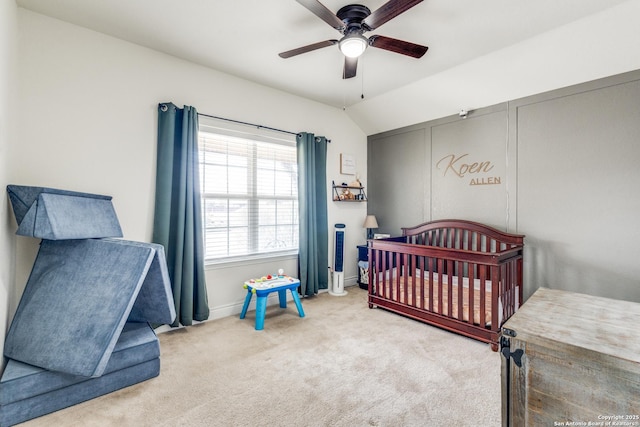 carpeted bedroom featuring ceiling fan, lofted ceiling, and a nursery area