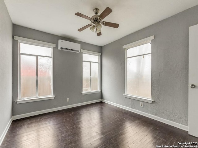 spare room featuring dark hardwood / wood-style flooring, ceiling fan, and a wall mounted AC