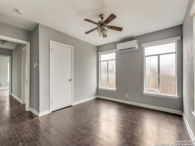 unfurnished room featuring an AC wall unit, ceiling fan, and dark hardwood / wood-style flooring