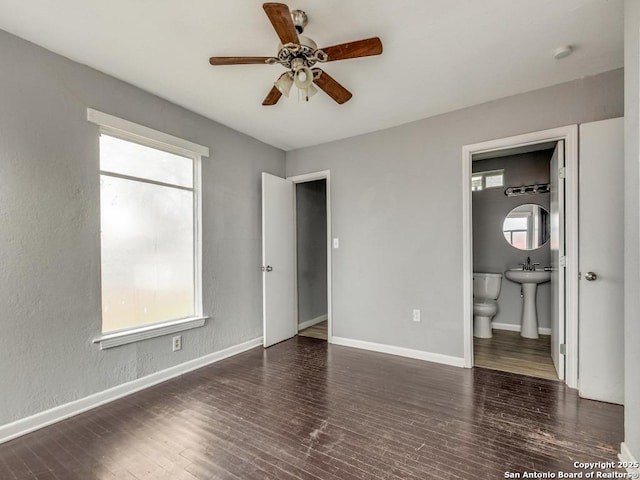 unfurnished bedroom featuring ensuite bathroom and dark wood-type flooring