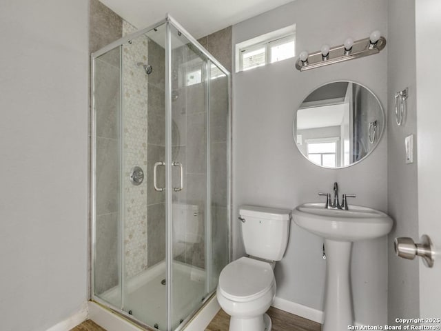 bathroom featuring hardwood / wood-style flooring, sink, an enclosed shower, and toilet