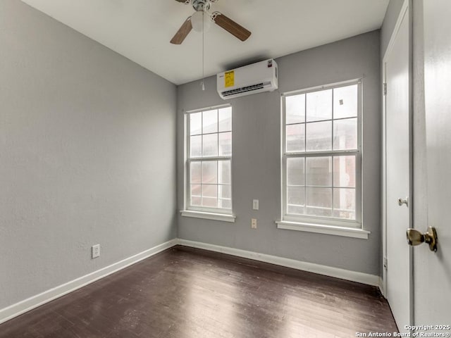 spare room with a wall mounted air conditioner, ceiling fan, and dark hardwood / wood-style flooring