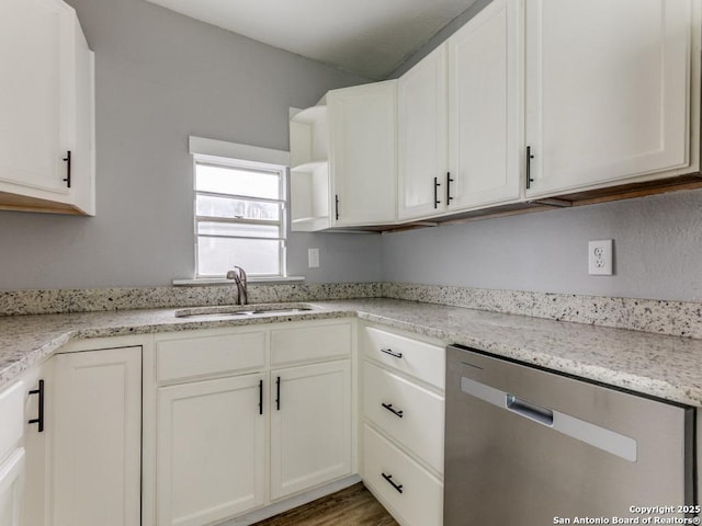 kitchen with sink, white cabinets, light stone countertops, and dishwasher