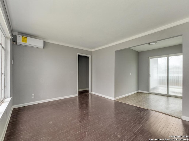 spare room featuring an AC wall unit, dark wood-type flooring, and ornamental molding