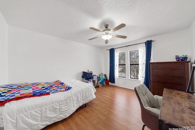 bedroom with ceiling fan, light hardwood / wood-style flooring, and a textured ceiling