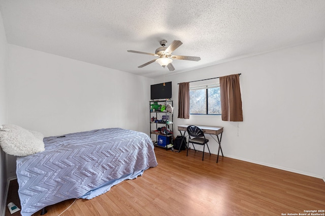 bedroom featuring hardwood / wood-style flooring, ceiling fan, and a textured ceiling