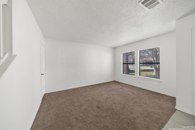 carpeted empty room with a textured ceiling