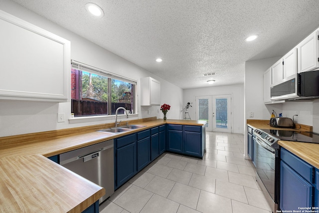 kitchen featuring appliances with stainless steel finishes, sink, blue cabinets, white cabinetry, and french doors