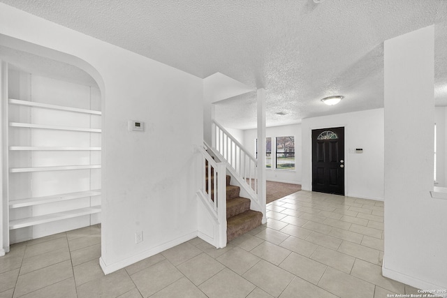 tiled entrance foyer with a textured ceiling