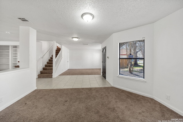 carpeted spare room with a textured ceiling