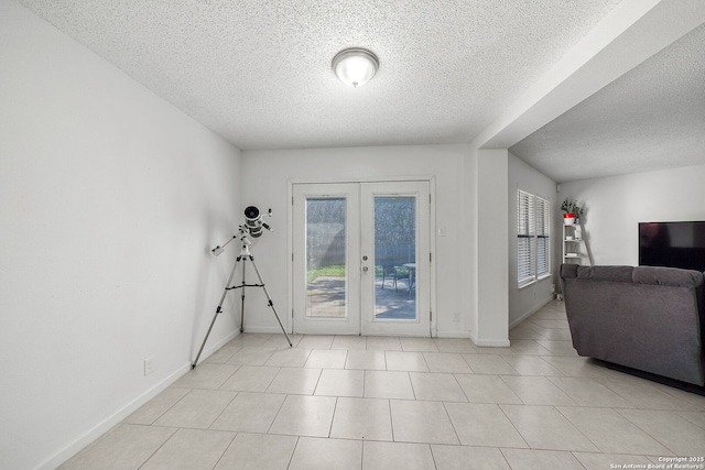 interior space with a textured ceiling and french doors