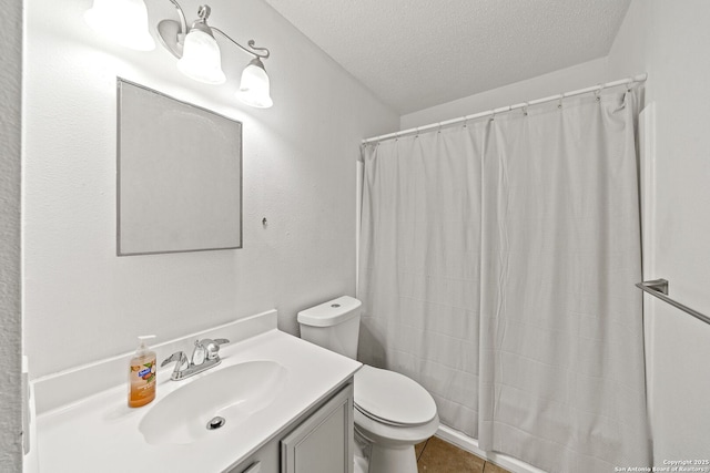 bathroom with curtained shower, vanity, a textured ceiling, toilet, and tile patterned floors