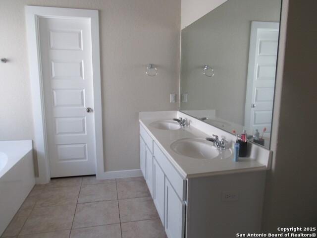 bathroom with vanity, tile patterned floors, and a tub to relax in