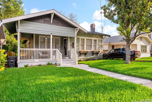 bungalow with covered porch and a front yard