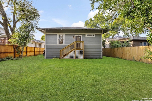 rear view of property with a lawn