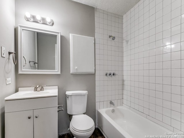 full bathroom with a textured ceiling, toilet, vanity, and tiled shower / bath combo