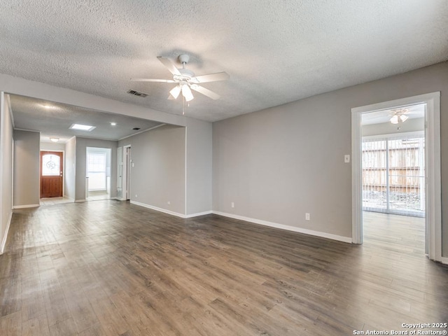 unfurnished living room with ceiling fan, dark wood-type flooring, and a textured ceiling