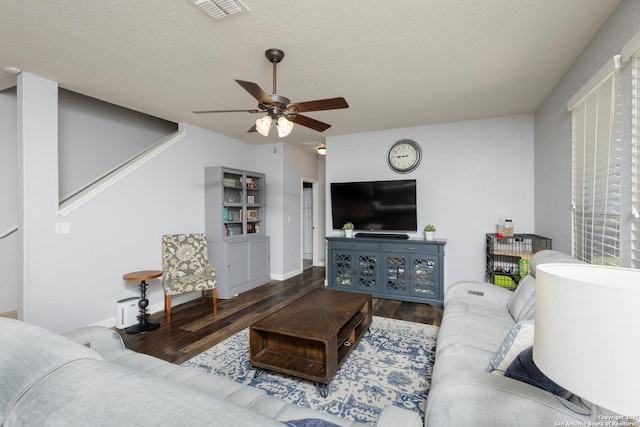 living room with ceiling fan, wood-type flooring, and a textured ceiling