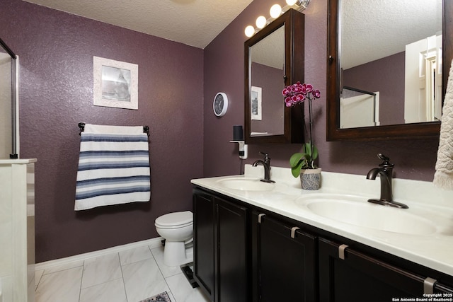 bathroom featuring toilet, vanity, and a textured ceiling