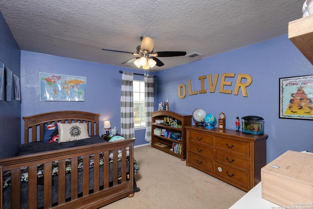 bedroom featuring a textured ceiling, light carpet, and ceiling fan