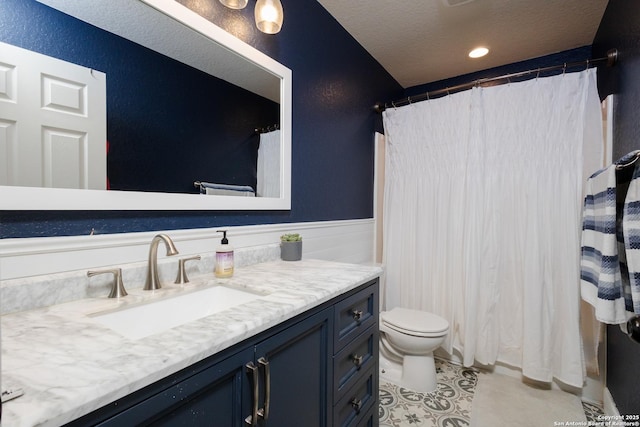 bathroom featuring tile patterned floors, a textured ceiling, toilet, and vanity