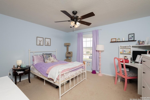 carpeted bedroom with ceiling fan and a textured ceiling