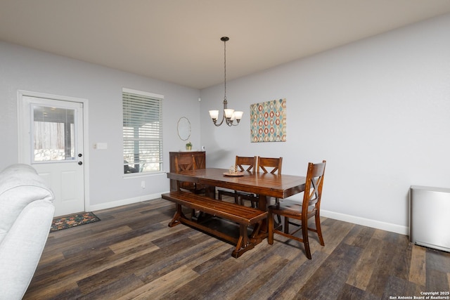 dining space featuring dark wood-type flooring and a chandelier