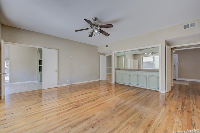 unfurnished living room featuring ceiling fan, baseboards, visible vents, and light wood-style floors