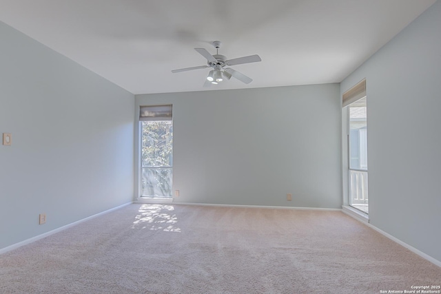 empty room featuring light colored carpet, plenty of natural light, and baseboards