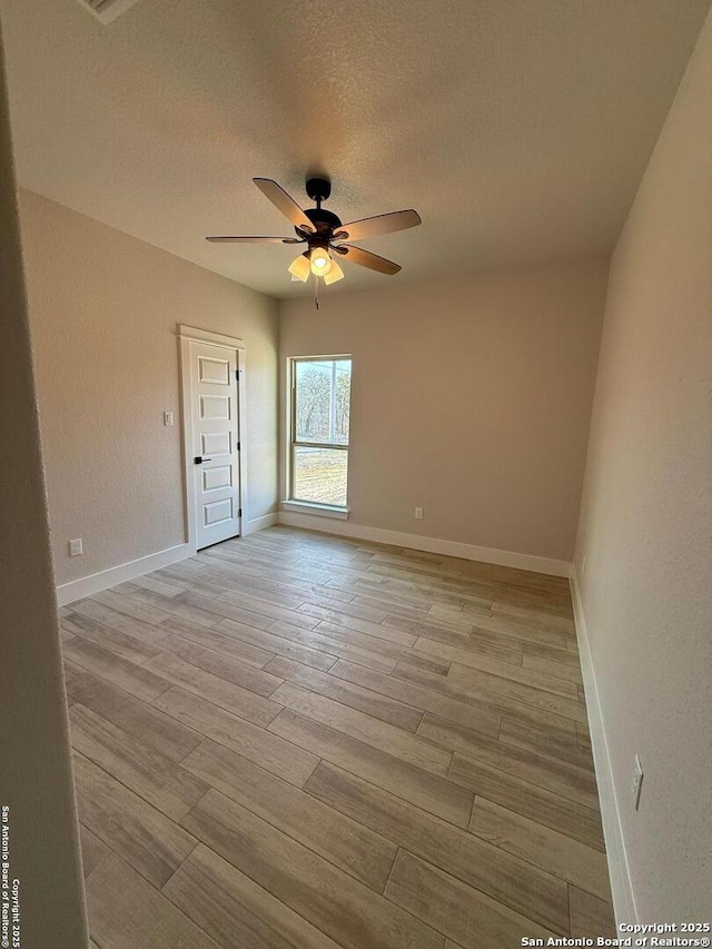 unfurnished room featuring a textured ceiling, ceiling fan, and light hardwood / wood-style floors